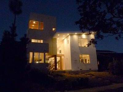 Kerner Ho Residence illuminated at night, showcasing its modern lines, large windows, and warm interior lighting.