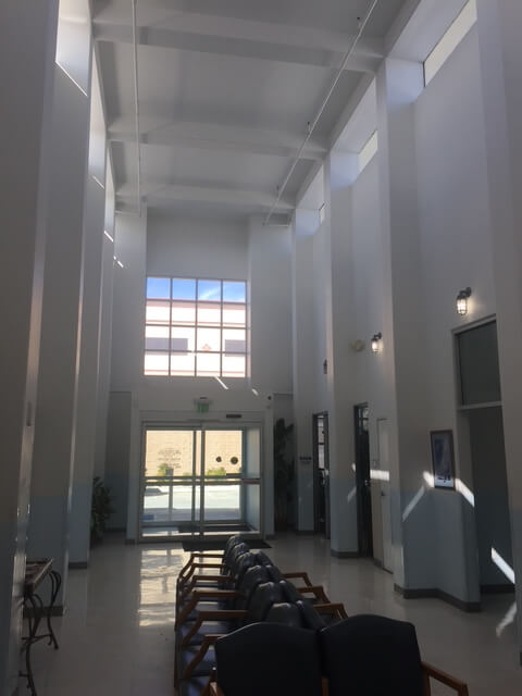 Entry hall of the Desert Cities Kidney Dialysis Center featuring tall columns, skylights, and a waiting area with natural daylight.