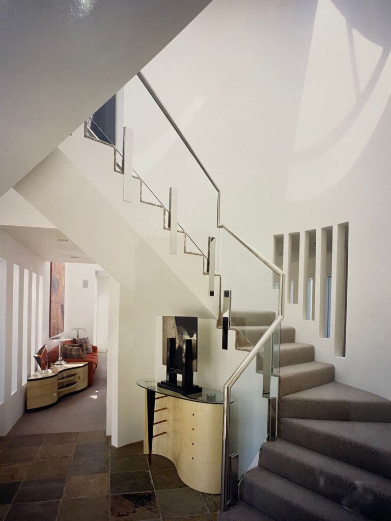 Interior staircase of the Shore Residence featuring sculptural forms, filtered daylight, and custom cabinetry along the hallway.