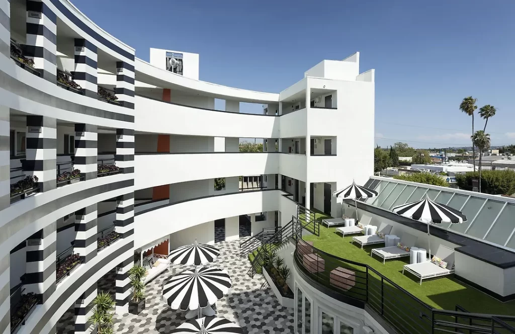 Curved courtyard architecture at The Carlyle Inn in West Los Angeles featuring layered balconies and outdoor seating.