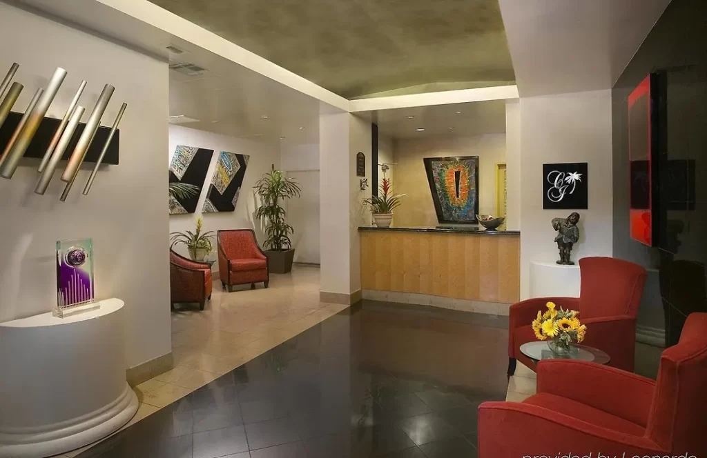 Hotel lobby interior at The Carlyle Inn in West Los Angeles featuring contemporary seating, artwork, and reception desk.